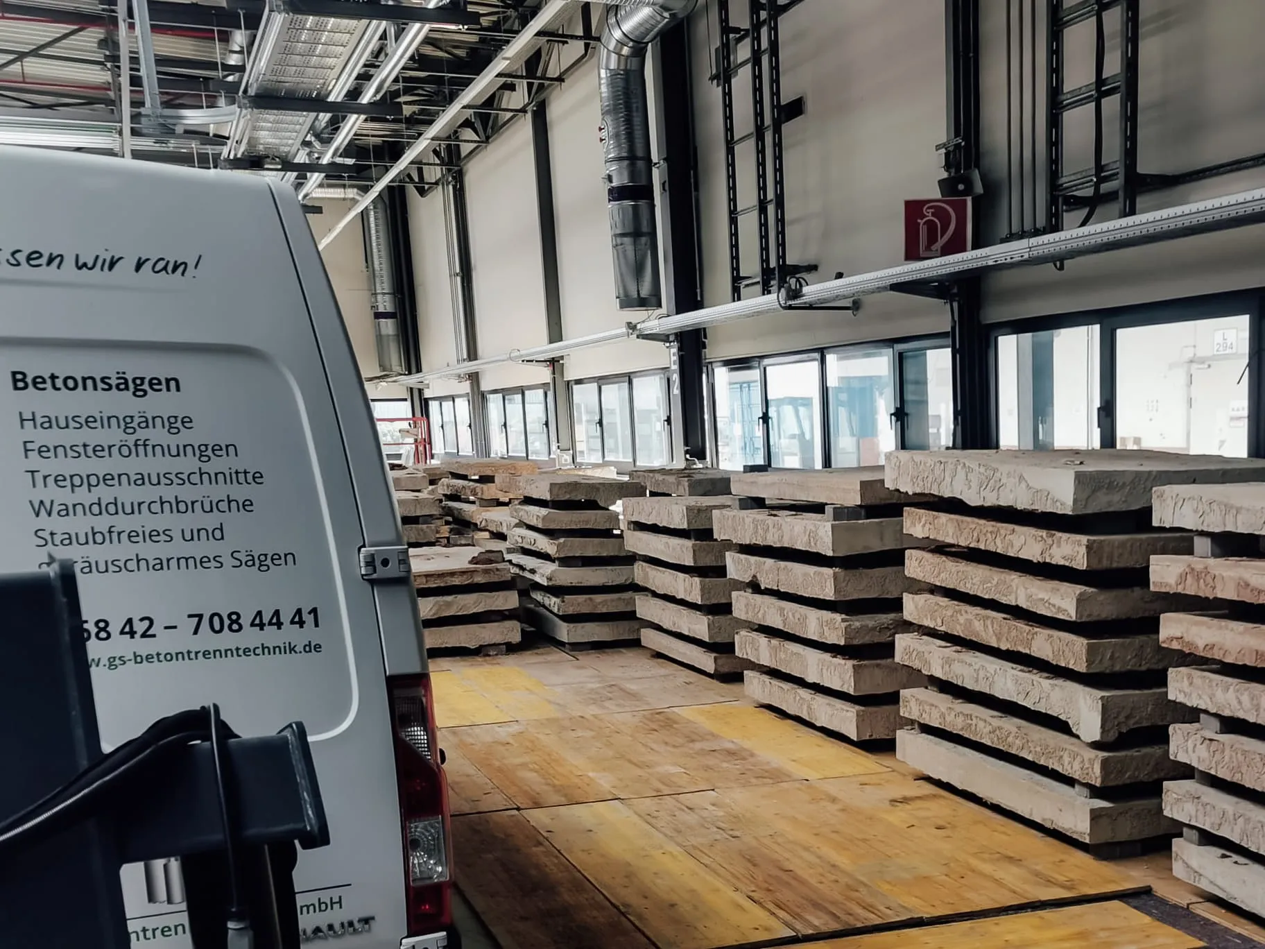 Gestapelte Betonfertigteile in einer Industriehalle mit bearbeitetem Betonboden