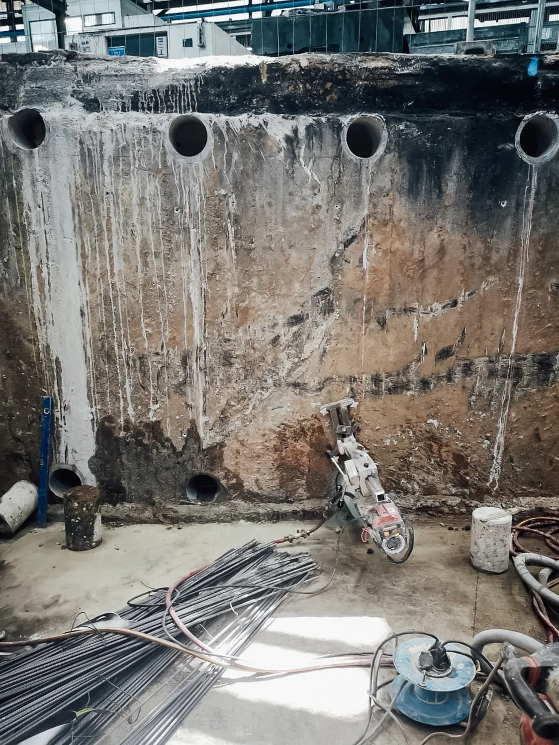 Kernbohrgerät vor einer Kellerwand aus Beton in einer Rohbaubaustelle